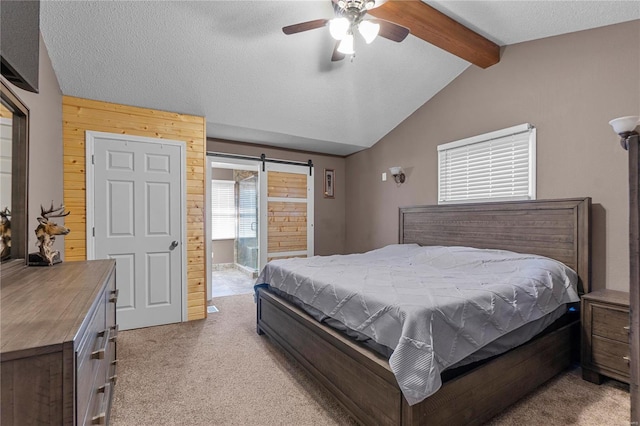 bedroom with lofted ceiling with beams, ceiling fan, a barn door, light carpet, and a textured ceiling