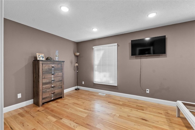 bedroom featuring a textured ceiling and light wood-type flooring