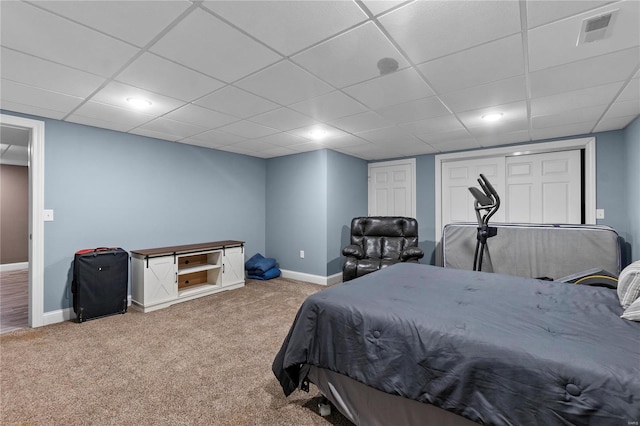 bedroom featuring light carpet and a paneled ceiling