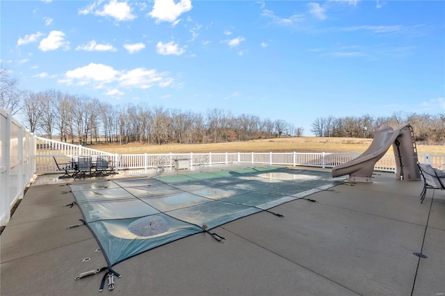 view of pool featuring a water slide and a patio