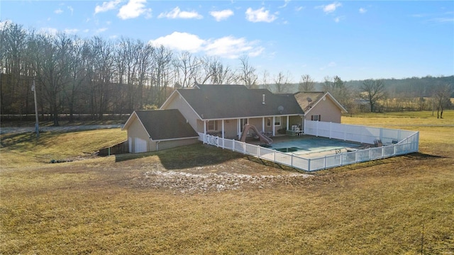 back of house with a covered pool and a lawn