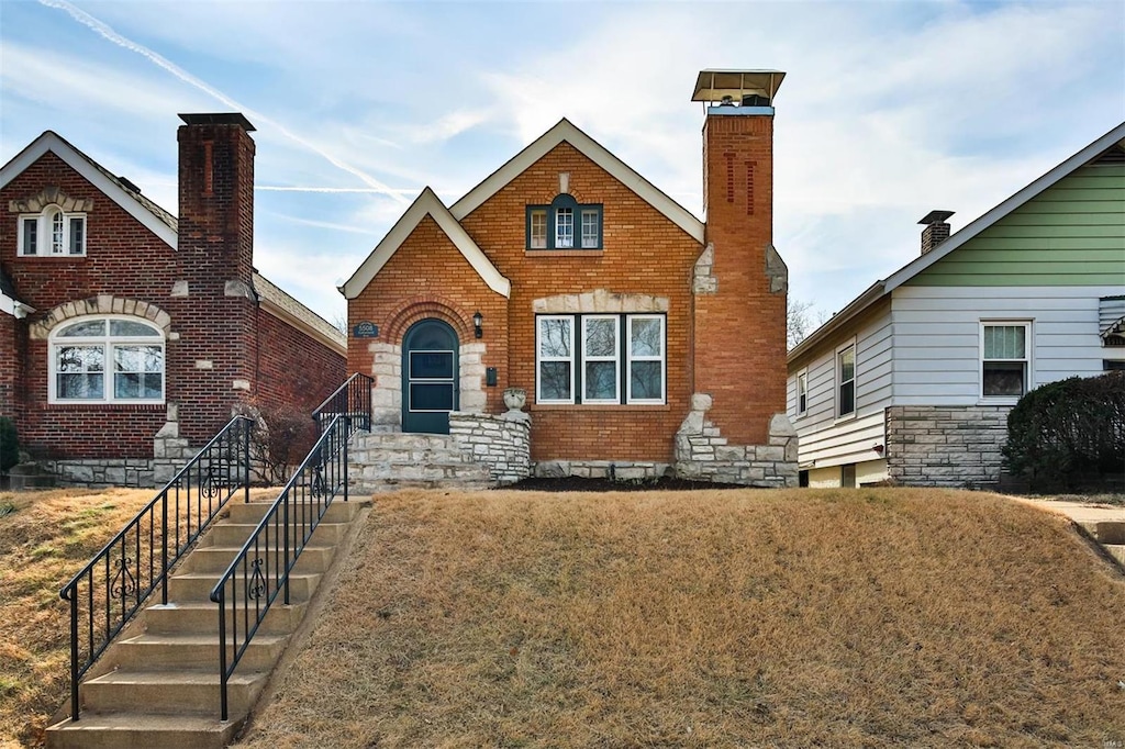 tudor-style house featuring a front lawn