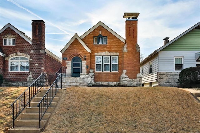 tudor-style house featuring a front lawn