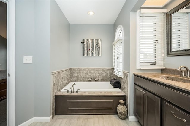 bathroom featuring hardwood / wood-style flooring, vanity, and a bath