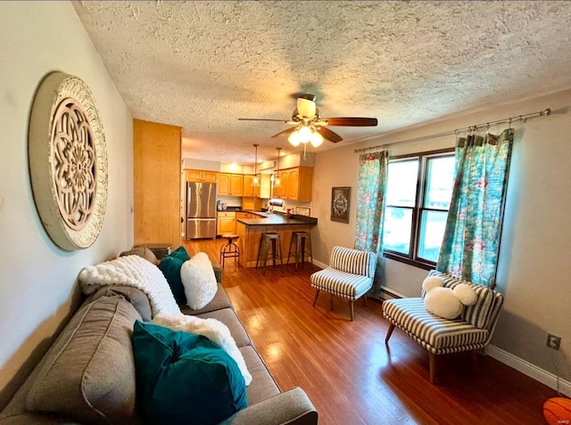 living room with sink, hardwood / wood-style flooring, a textured ceiling, and ceiling fan