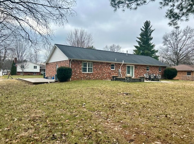 rear view of property featuring a lawn and a patio area