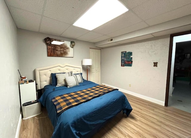 bedroom featuring a paneled ceiling and wood-type flooring