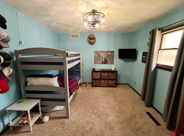 carpeted bedroom with an inviting chandelier