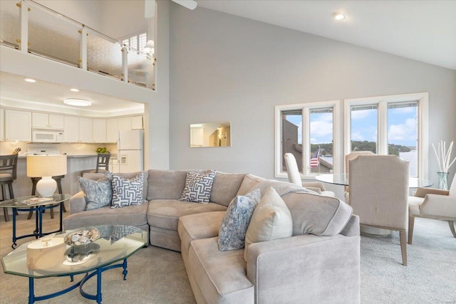 carpeted living room featuring high vaulted ceiling