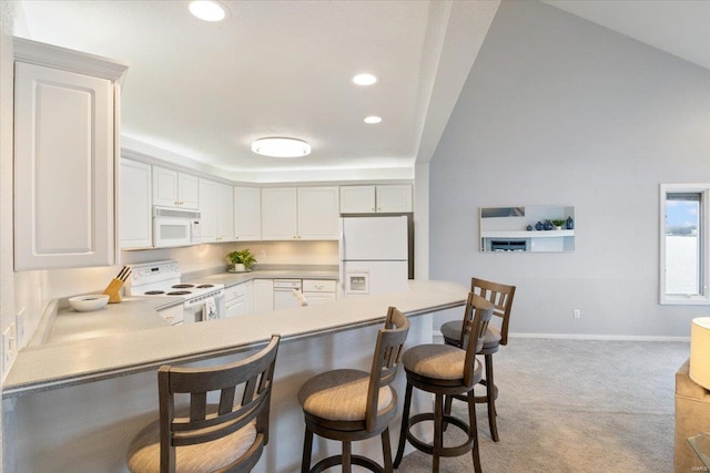 kitchen with a breakfast bar area, white cabinets, light colored carpet, kitchen peninsula, and white appliances