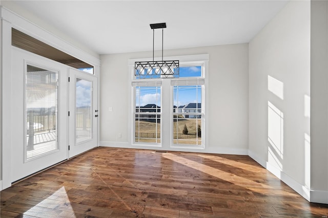 unfurnished dining area with dark hardwood / wood-style flooring