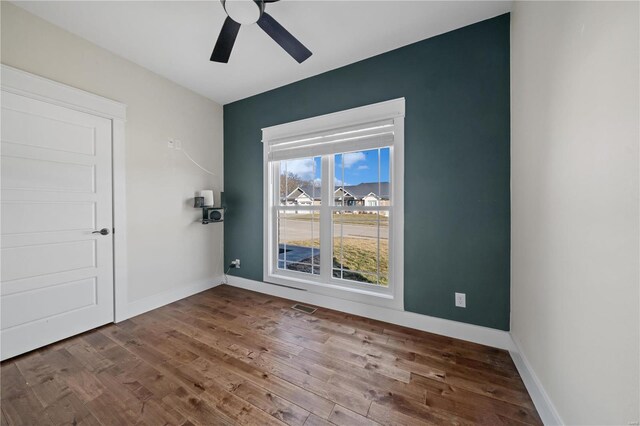 spare room with hardwood / wood-style floors and ceiling fan