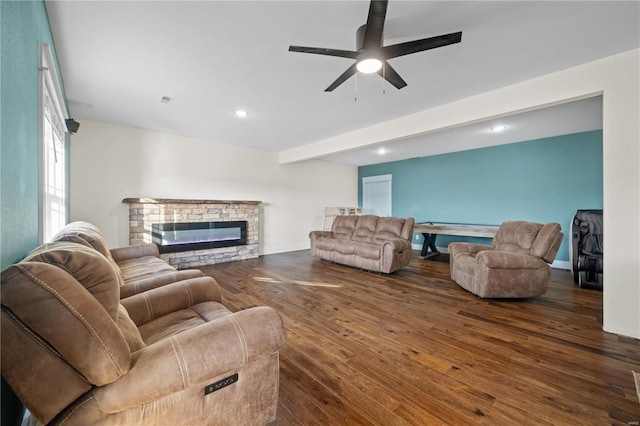 living room featuring dark hardwood / wood-style floors, ceiling fan, a fireplace, and beamed ceiling