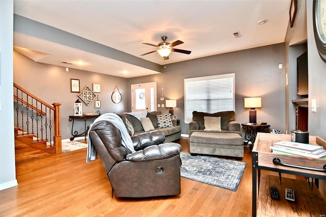 living room with ceiling fan and light hardwood / wood-style flooring