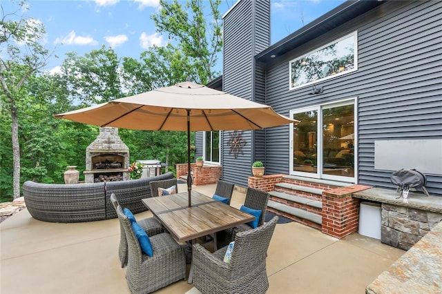 view of patio with area for grilling and exterior fireplace