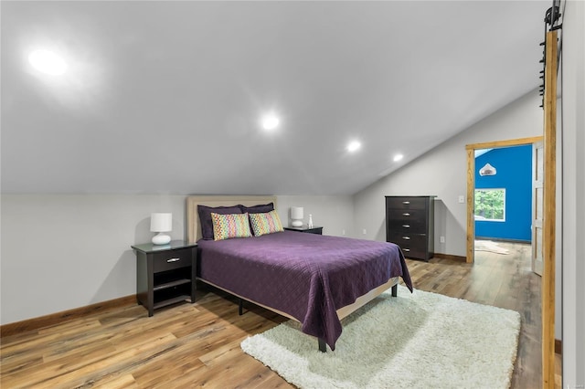 bedroom with lofted ceiling and hardwood / wood-style floors