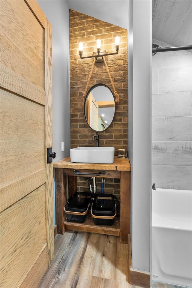 bathroom featuring vaulted ceiling, hardwood / wood-style floors, and vanity