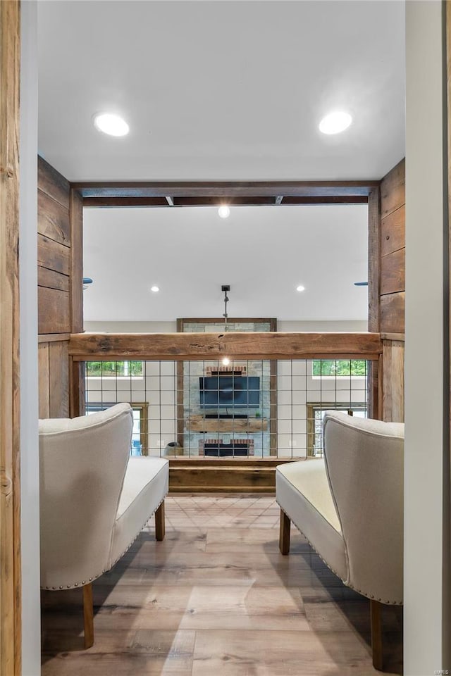 sitting room with wood-type flooring and wooden walls