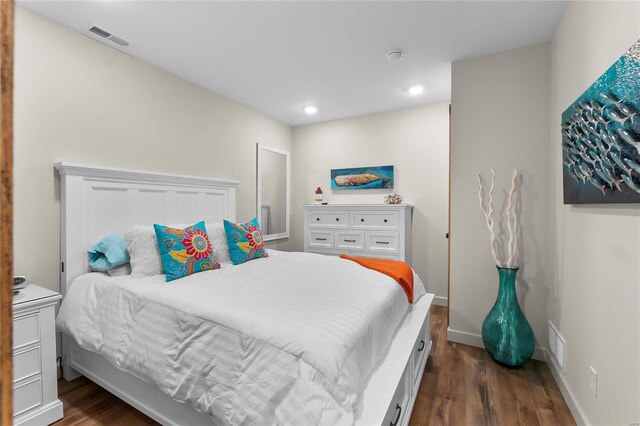 bedroom with dark wood-type flooring