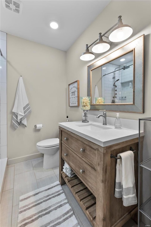 bathroom featuring vanity, tile patterned flooring, a shower, and toilet