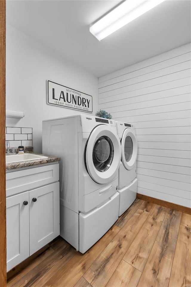 laundry room featuring cabinets, sink, hardwood / wood-style floors, and independent washer and dryer