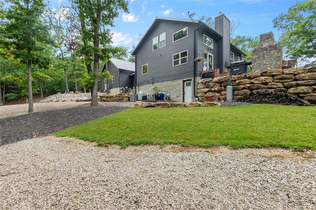 view of property exterior with central air condition unit and a lawn