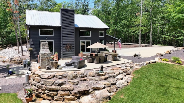 rear view of house featuring a fireplace and a patio