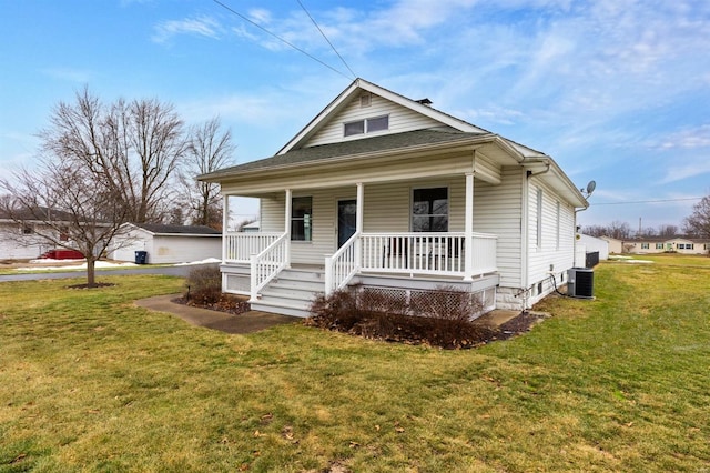 bungalow-style home featuring cooling unit, covered porch, and a front yard