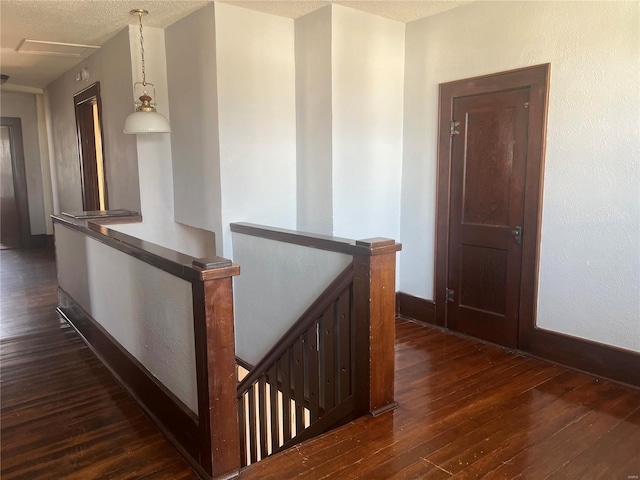 hallway featuring dark hardwood / wood-style floors and a textured ceiling