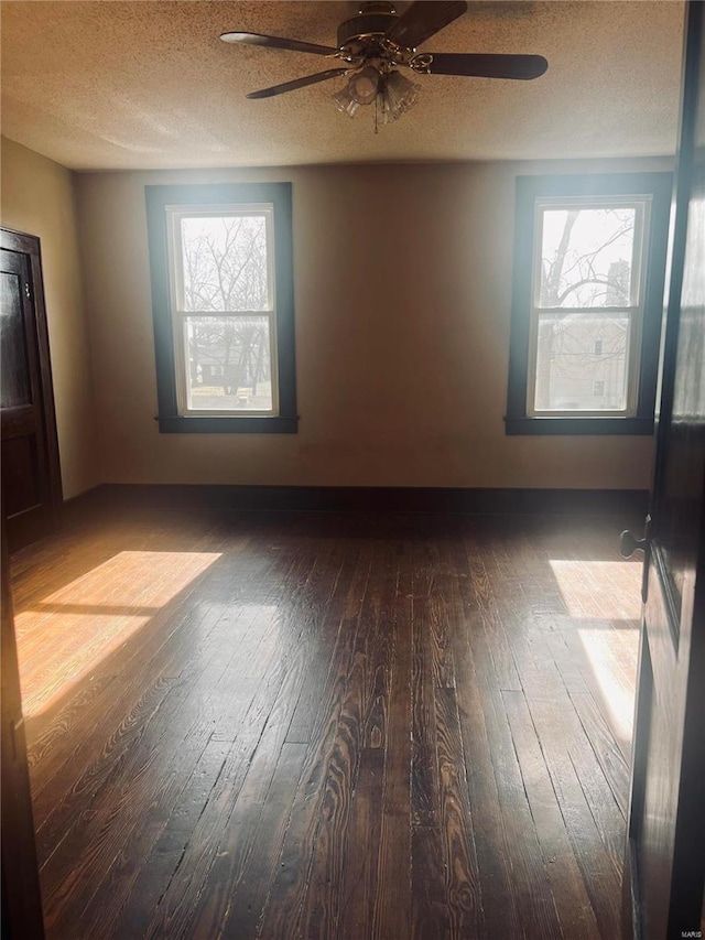 empty room featuring hardwood / wood-style floors, plenty of natural light, and a textured ceiling