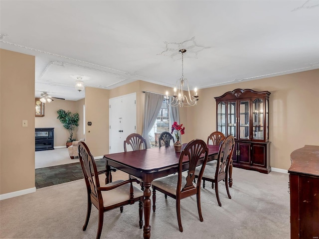 carpeted dining area featuring ceiling fan with notable chandelier