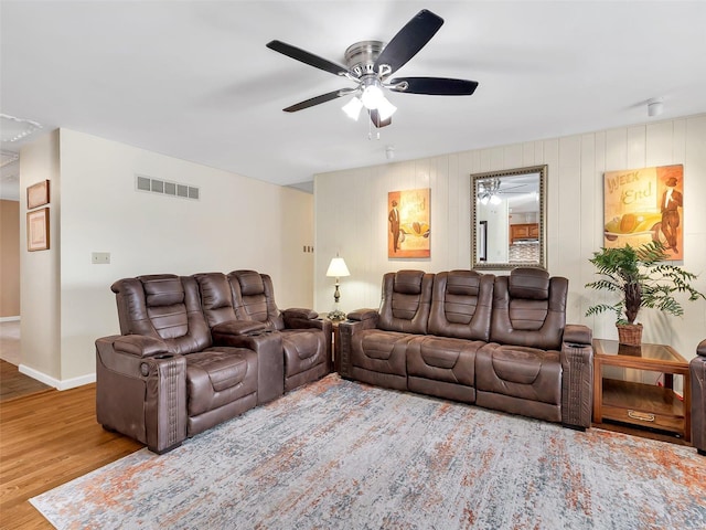 living room with wood-type flooring and ceiling fan