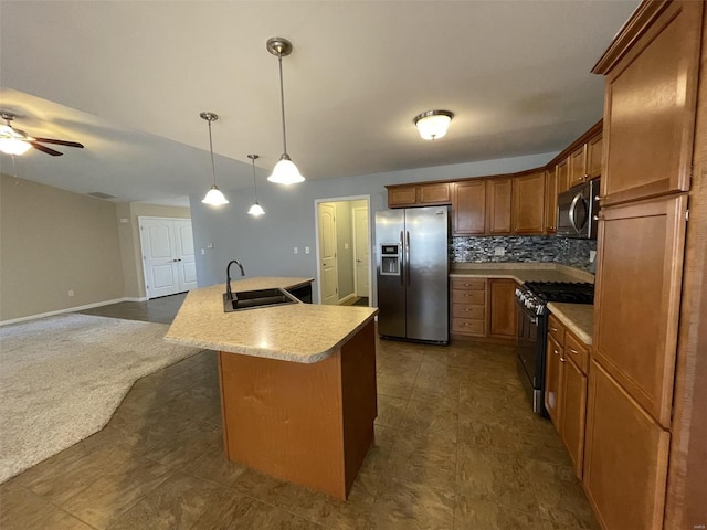 kitchen with appliances with stainless steel finishes, decorative light fixtures, tasteful backsplash, sink, and a center island with sink