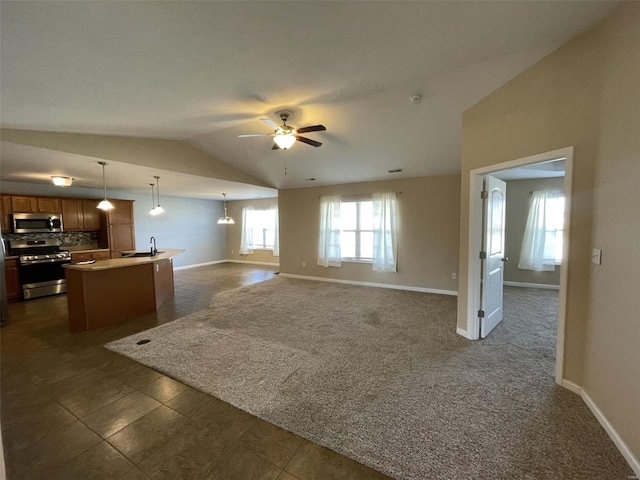 interior space with lofted ceiling, sink, ceiling fan, and dark carpet