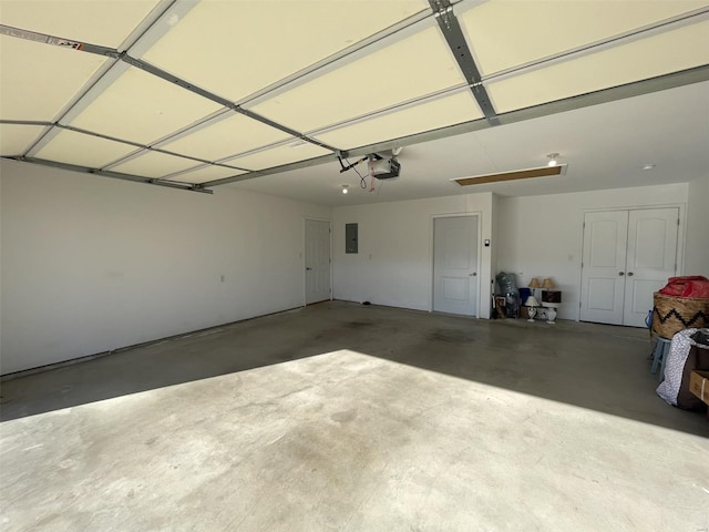 garage with a garage door opener and electric panel