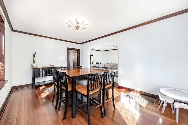 dining area featuring ornamental molding and wood-type flooring