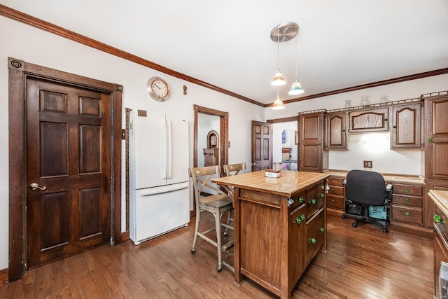 kitchen with dark wood-type flooring, a kitchen island, hanging light fixtures, and white fridge