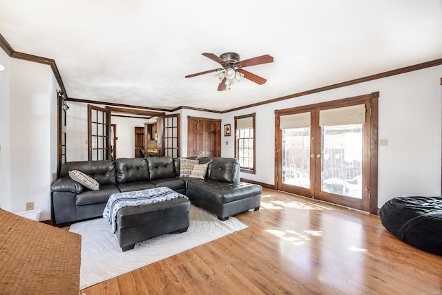 living room with french doors, ornamental molding, and light hardwood / wood-style flooring