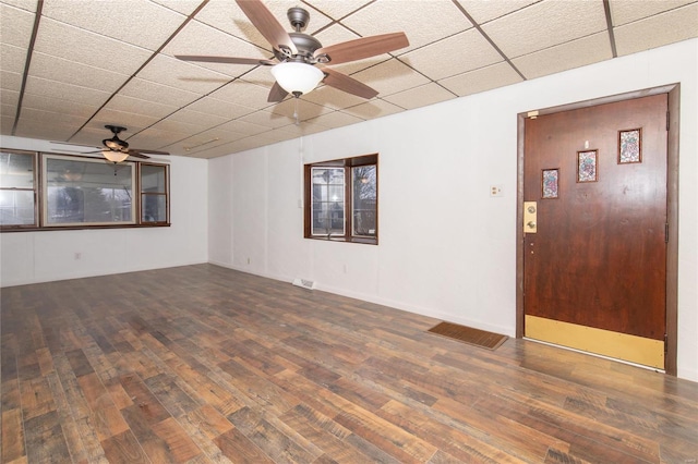 empty room featuring a paneled ceiling, dark hardwood / wood-style floors, and ceiling fan