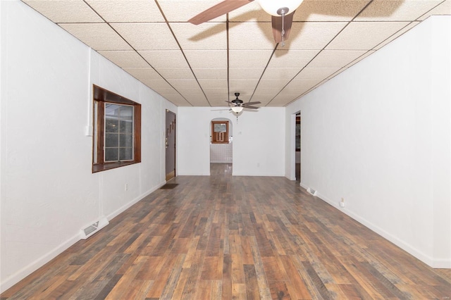 spare room featuring dark wood-type flooring, a drop ceiling, and ceiling fan