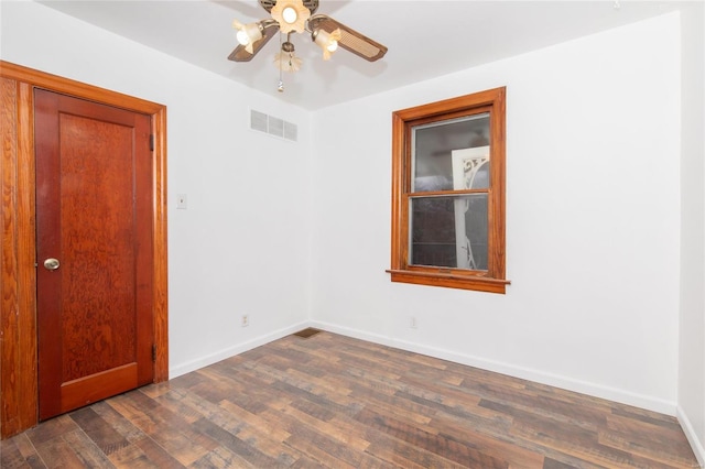 spare room featuring dark wood-type flooring and ceiling fan