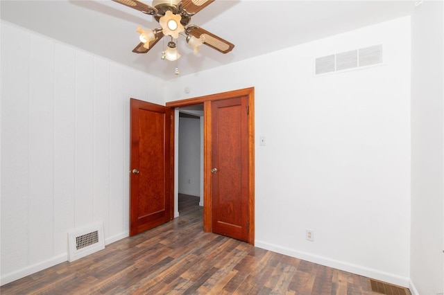 spare room featuring dark wood-type flooring and ceiling fan