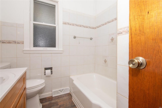 bathroom with tile walls, vanity, wood-type flooring, and toilet