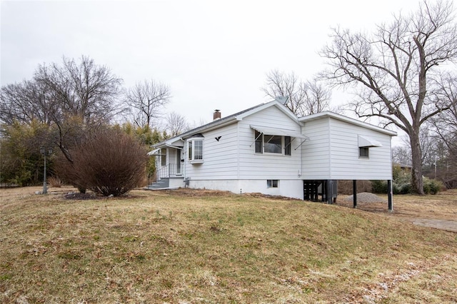 view of side of property featuring a lawn and a chimney