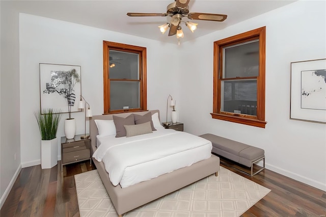 bedroom featuring ceiling fan, baseboards, and wood finished floors