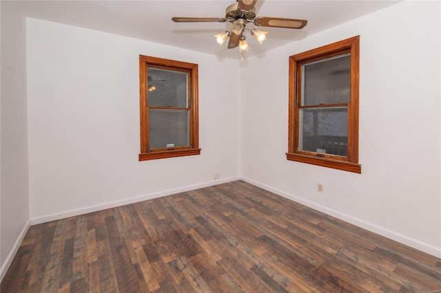 unfurnished room featuring ceiling fan, dark wood-type flooring, and baseboards