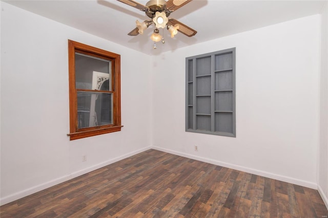 spare room featuring dark wood-style floors, ceiling fan, and baseboards