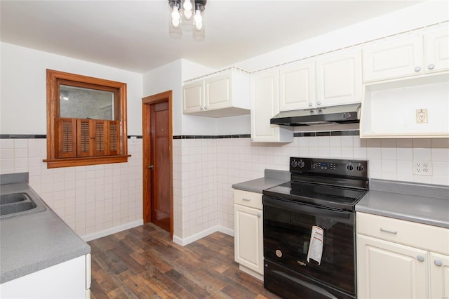 kitchen with under cabinet range hood, electric range, dark wood-style floors, and white cabinets