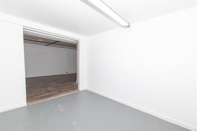 unfurnished bedroom featuring finished concrete floors, a closet, and baseboards