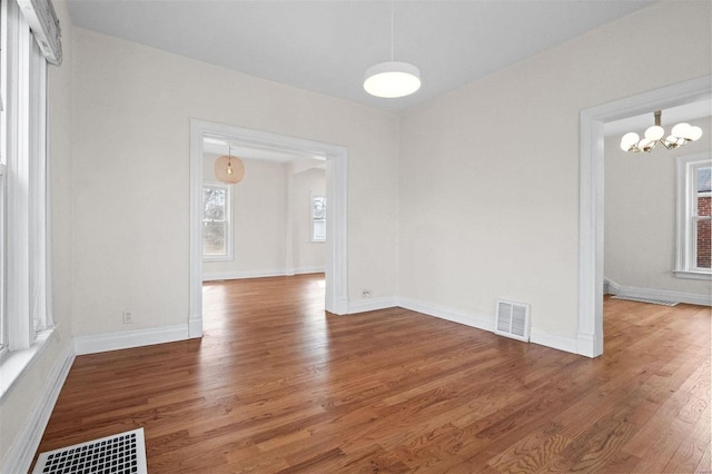 unfurnished dining area with hardwood / wood-style flooring and a chandelier